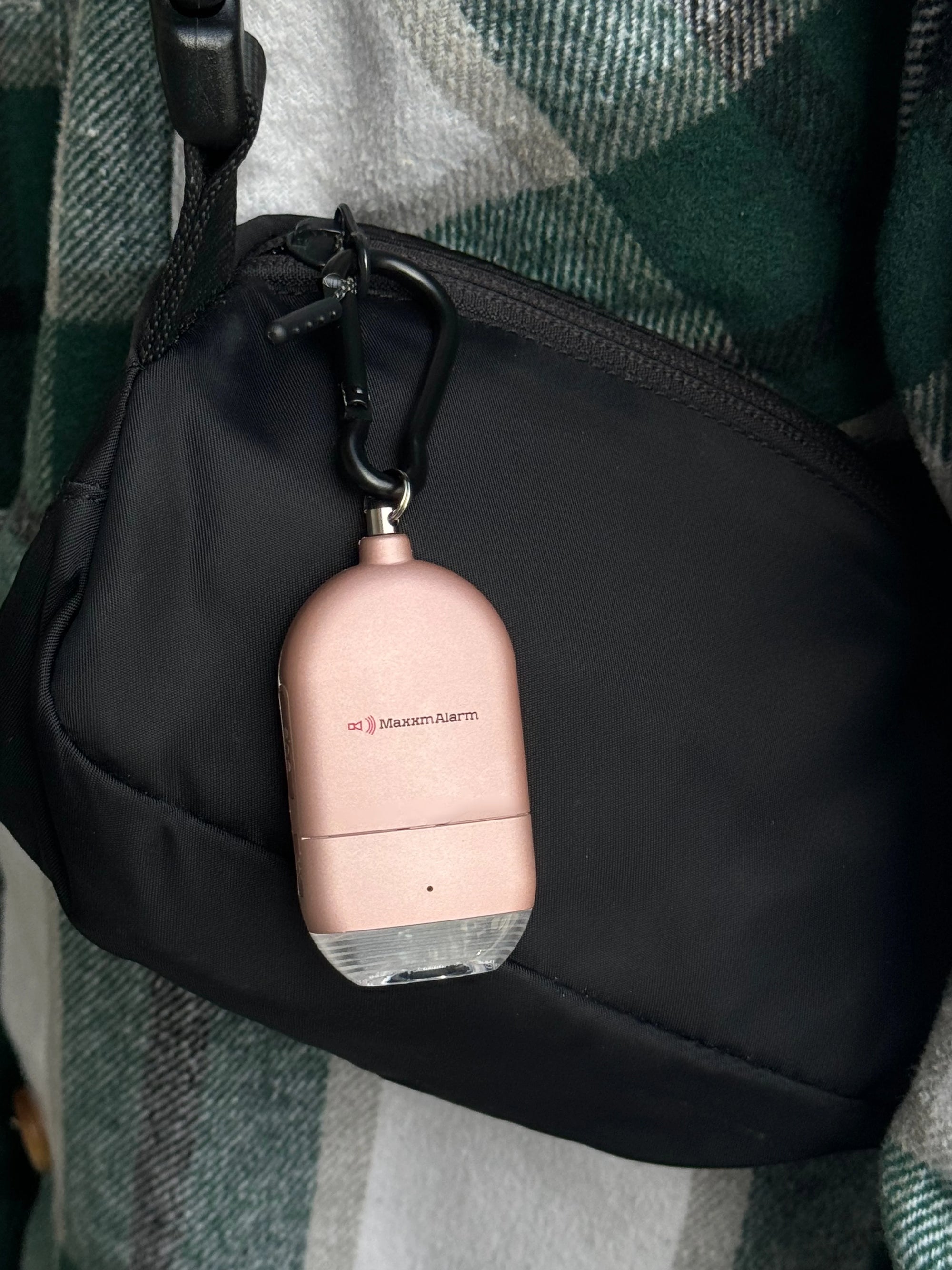 MaxxmAlarm Illume 130dB Personal Alarm attached to a handbag, featuring a portable emergency alarm and safety light for personal protection.